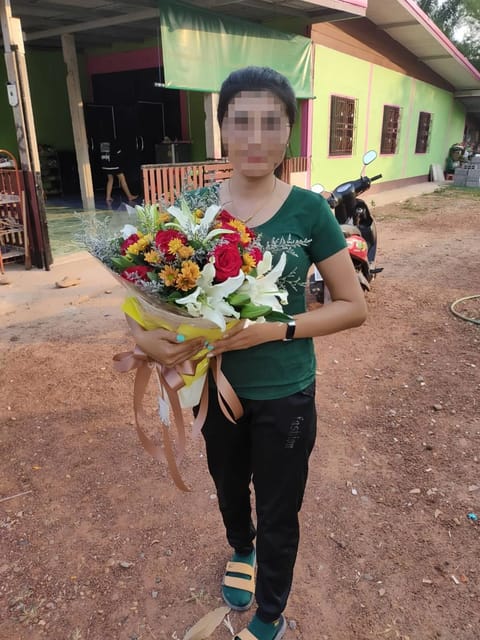 ลูกค้ากำลังรับช่อดอกไม้ที่คล้ายกัน มีกุหลาบแดง ลิลลี่ขาว เบญจมาศส้มและเหลือง สแตติสม่วงอ่อน (สินค้าอื่น)