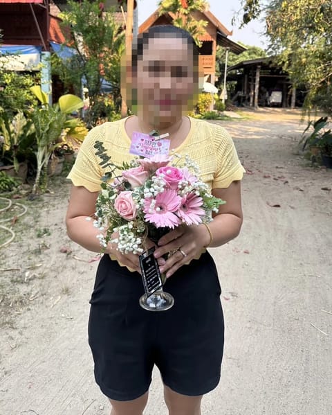ลูกค้ากำลังรับแจกันดอกไม้ที่คล้ายกัน มีเยอบีร่าชมพู กุหลาบชมพู ยิปโซขาว ใบยูคาลิปตัส (สินค้าอื่น)