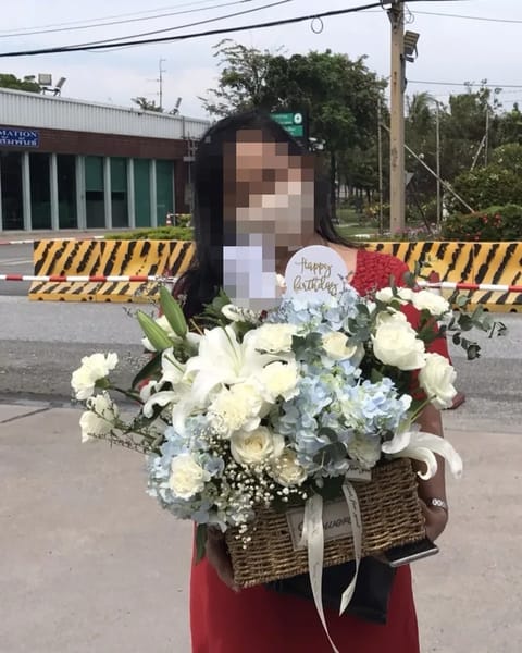 ลูกค้ากำลังรับกระเช้าดอกไม้ที่คล้ายกัน มีกุหลาบขาว ไฮเดรนเยียฟ้า (สินค้าอื่น)