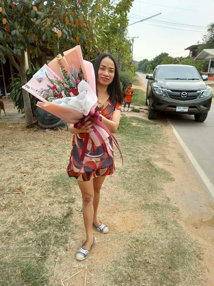 ลูกค้ากำลังรับช่อกุหลาบและคาร์เนชั่น สีแดง ชมพู และขาว (สินค้าอื่น)