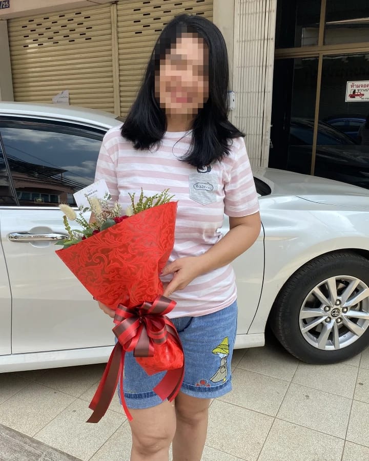 ลูกค้ากำลังรับช่อดอกไม้ที่คล้ายกัน มีกุหลาบแดง ดอกไม้สีครีม (สินค้าอื่น)