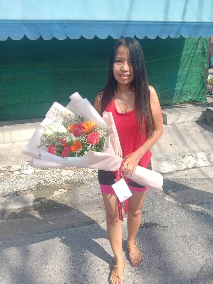 ลูกค้ากำลังรับช่อกุหลาบ คาร์เนชั่น และลิลลี่ สีชมพู ส้ม และขาว (สินค้าอื่น)