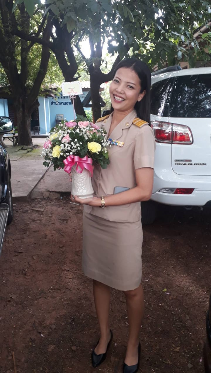 ลูกค้ากำลังรับช่อคาร์เนชั่น กุหลาบ และเบญจมาศ สีชมพู เหลือง และขาว (สินค้าอื่น)