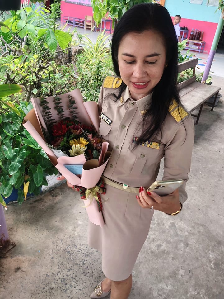 ลูกค้ากำลังรับช่อกุหลาบ เบญจมาศ และคาร์เนชั่น สีแดง เหลือง และชมพู (สินค้าอื่น)