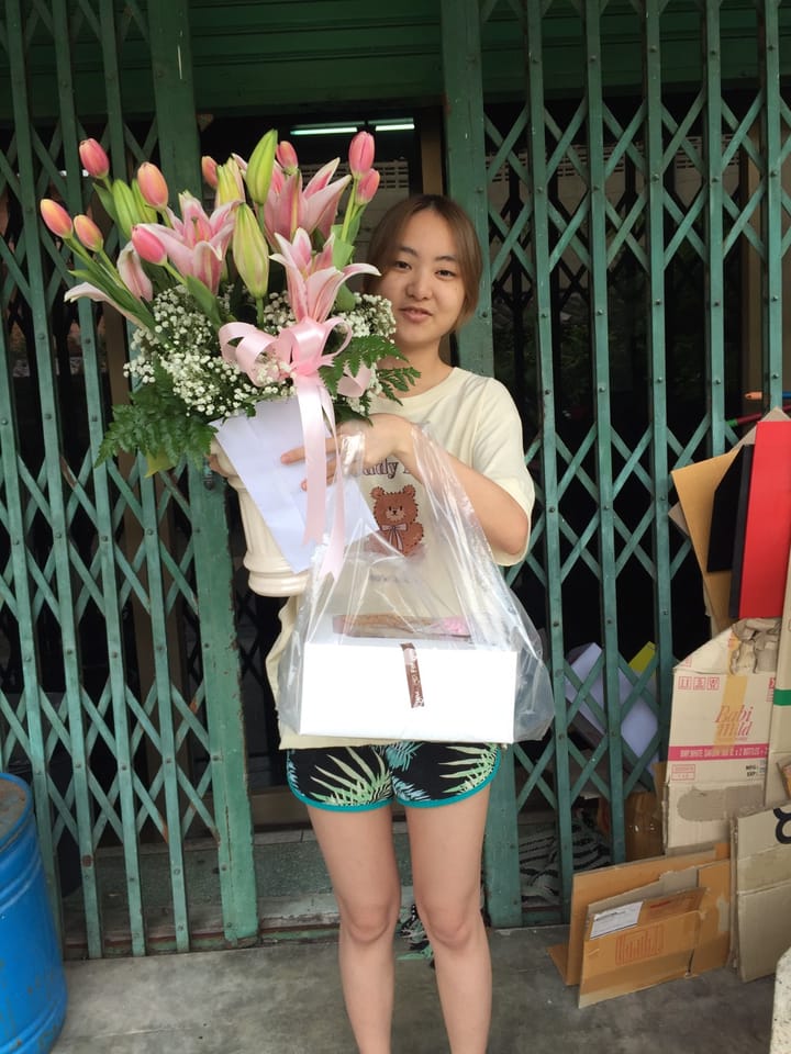 ลูกค้ากำลังรับช่อลิลลี่และทิวลิป สีชมพูและขาว (สินค้าอื่น)
