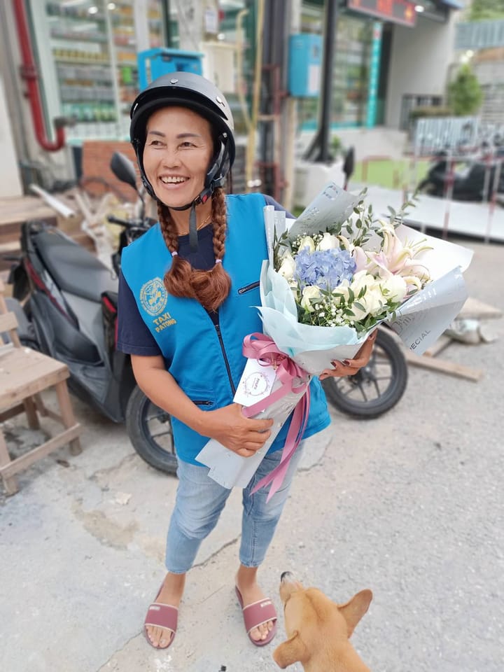 ลูกค้ากำลังรับช่อกุหลาบ ลิลลี่ และไฮเดรนเยีย สีขาว ชมพู และฟ้า (สินค้าอื่น)