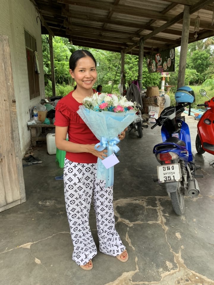 ลูกค้ากำลังรับช่อกุหลาบและลิลลี่ สีขาว ชมพู และฟ้า (สินค้าอื่น)