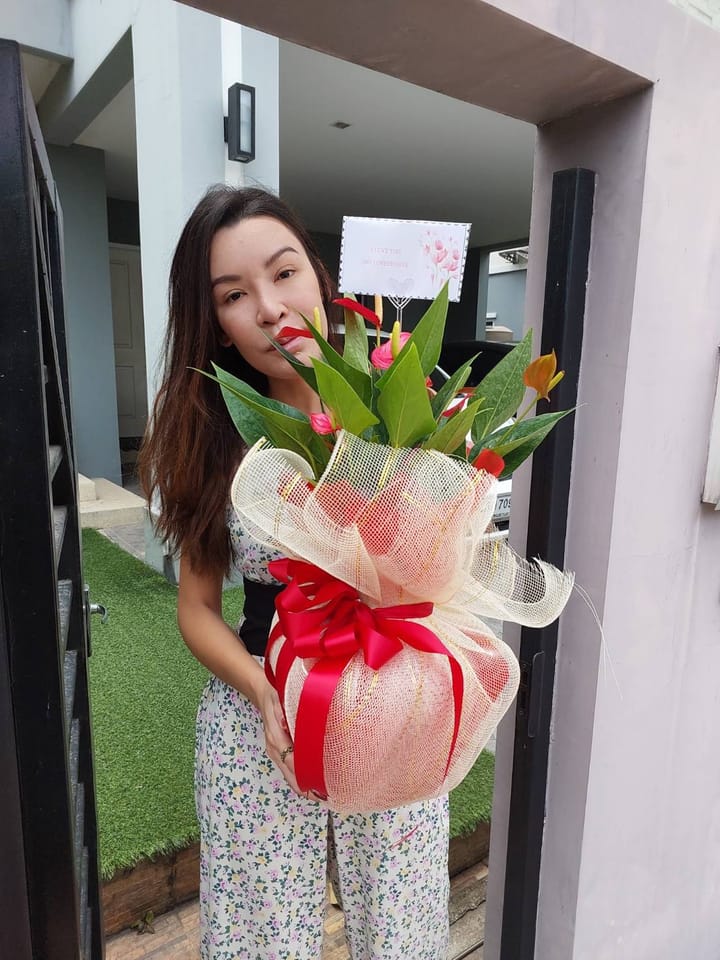 ลูกค้ากำลังรับช่อหน้าวัวและกุหลาบ สีแดงและเหลือง (สินค้าอื่น)