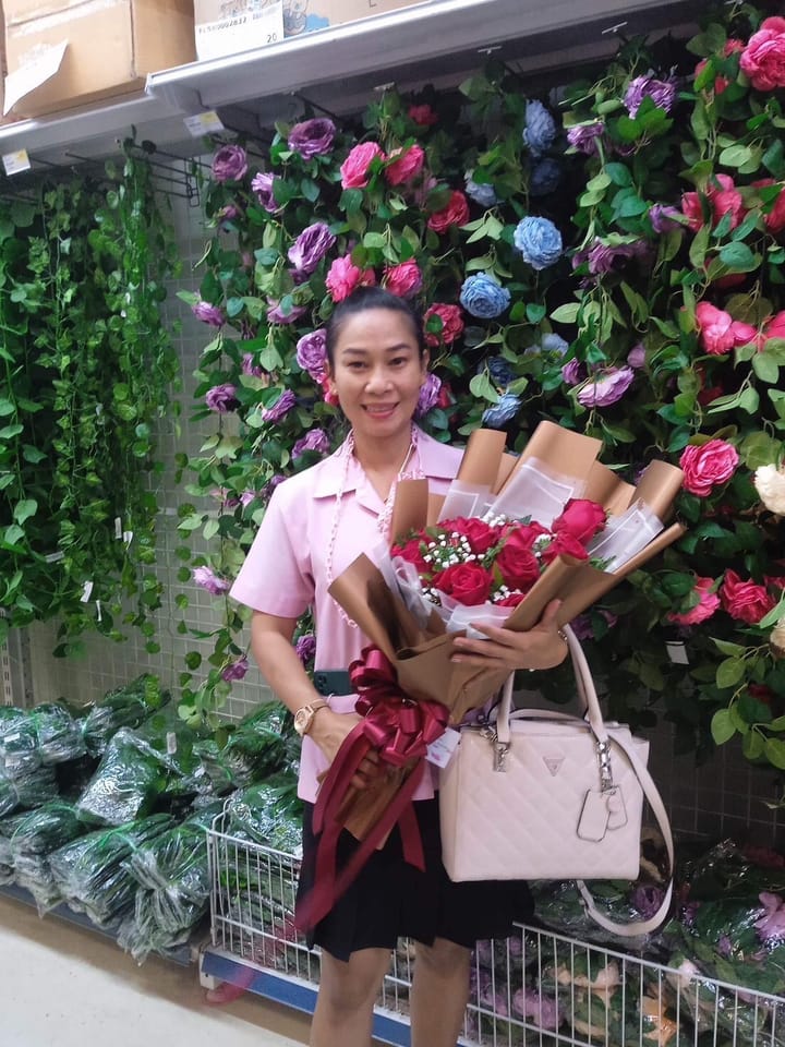 ลูกค้ากำลังรับช่อกุหลาบแดง ชมพู และม่วง (สินค้าอื่น)
