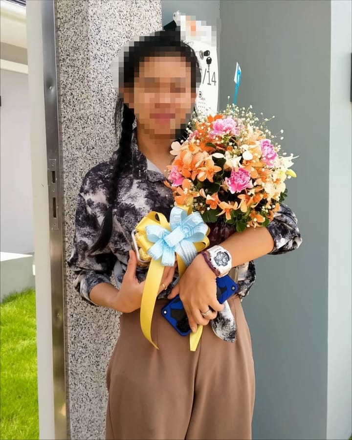ลูกค้ากำลังรับช่อดอกไม้ที่คล้ายกัน มีกล้วยไม้ส้มและขาว คาร์เนชั่นชมพู ยิปโซขาว (สินค้าอื่น)