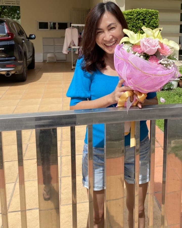 ลูกค้ากำลังรับช่อลิลลี่ กุหลาบ คาร์เนชั่น และยิปโซ สีชมพู เหลือง และขาว (สินค้าอื่น)