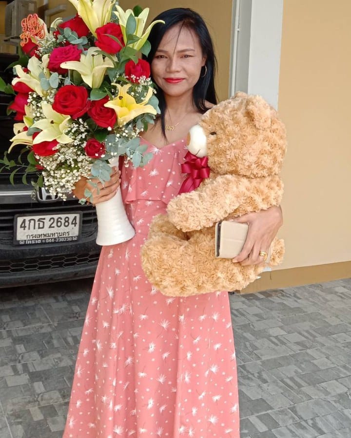 ลูกค้ากำลังรับช่อกุหลาบ ลิลลี่ และยิปโซ สีแดง เหลือง และขาว (สินค้าอื่น)
