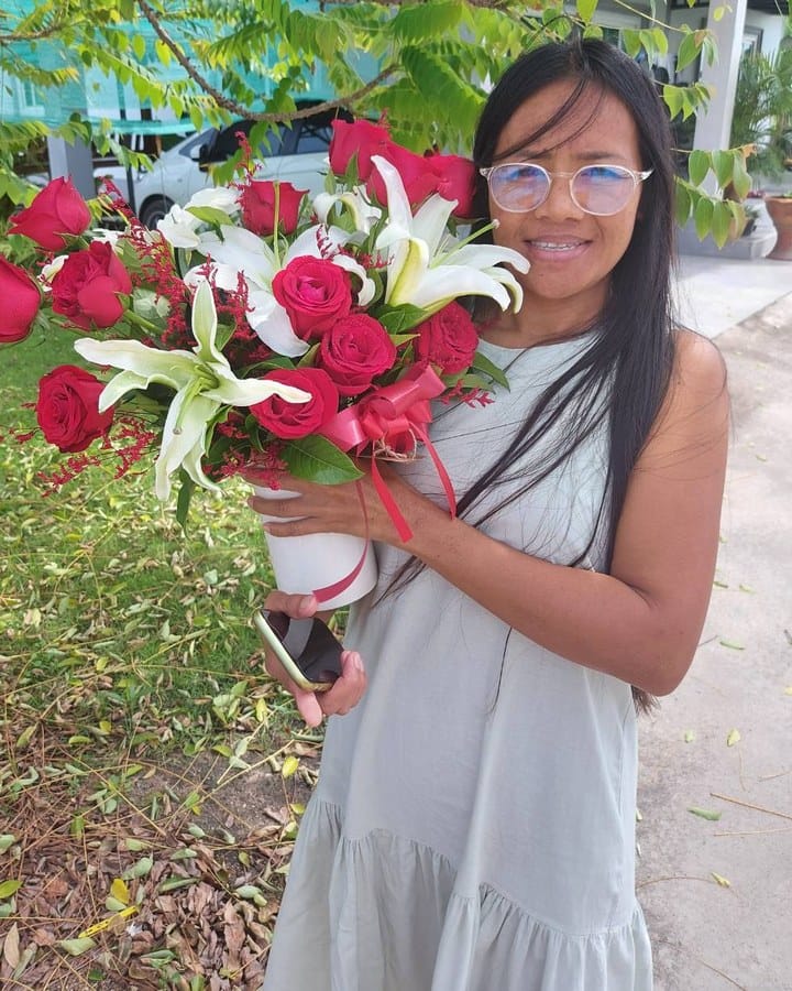 ลูกค้ากำลังรับช่อกุหลาบและลิลลี่ สีแดงและขาว (สินค้าอื่น)
