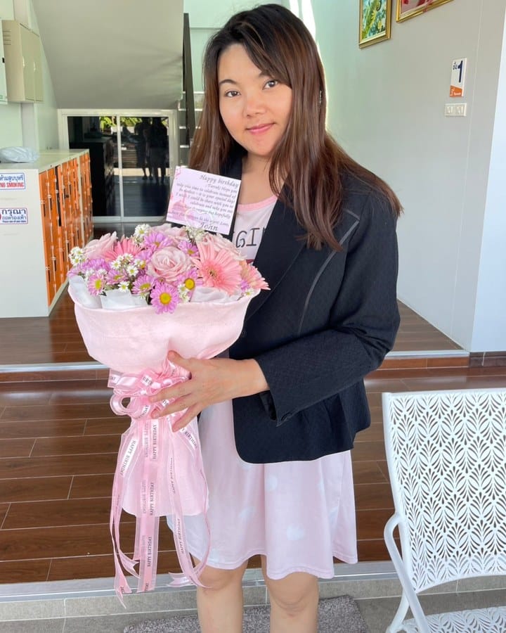 ลูกค้ากำลังรับช่อกุหลาบ เยอบีร่า เบญจมาศ และยิปโซ สีชมพู ขาว และเหลือง (สินค้าอื่น)