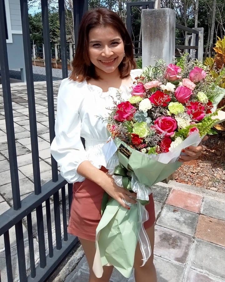 ลูกค้ากำลังรับช่อกุหลาบ คาร์เนชั่น และยิปโซ สีชมพู แดง และขาว (สินค้าอื่น)