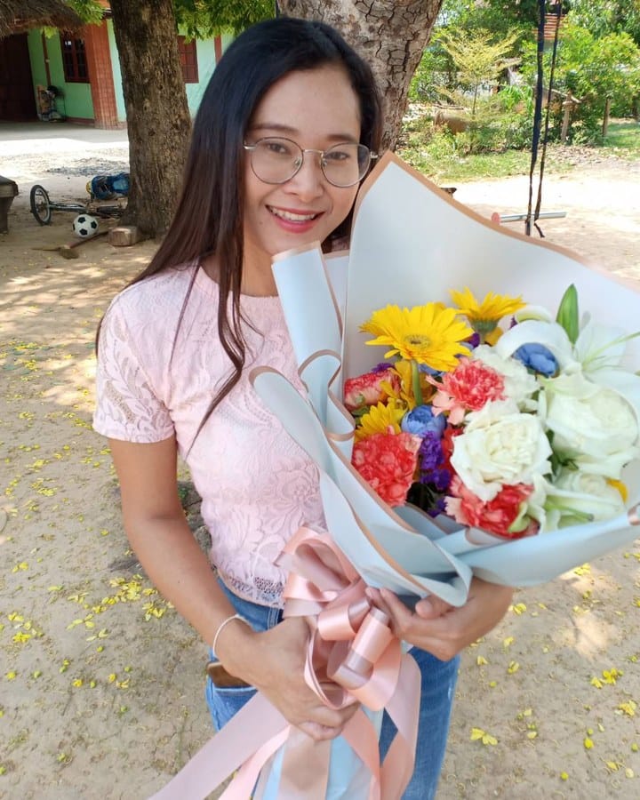 ลูกค้ากำลังรับช่อเยอบีร่า คาร์เนชั่น และลิลลี่ สีเหลือง แดง และขาว (สินค้าอื่น)
