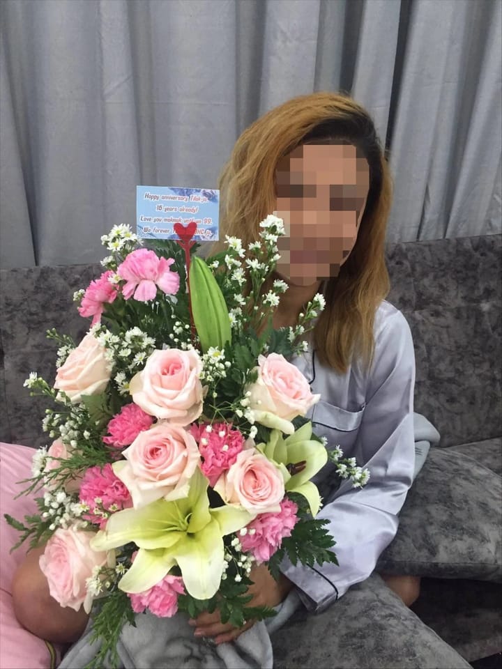 ลูกค้ากำลังรับกระเช้าดอกไม้ที่คล้ายกัน มีกุหลาบชมพู คาร์เนชั่นชมพู ลิลลี่เขียวและครีม ดอกไม้สีขาว (สินค้าอื่น)