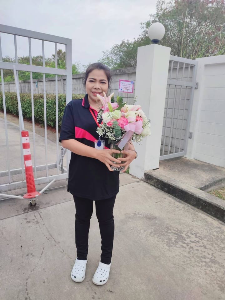 ลูกค้ากำลังรับช่อลิลลี่ กุหลาบ และคาร์เนชั่น สีชมพูและขาว (สินค้าอื่น)