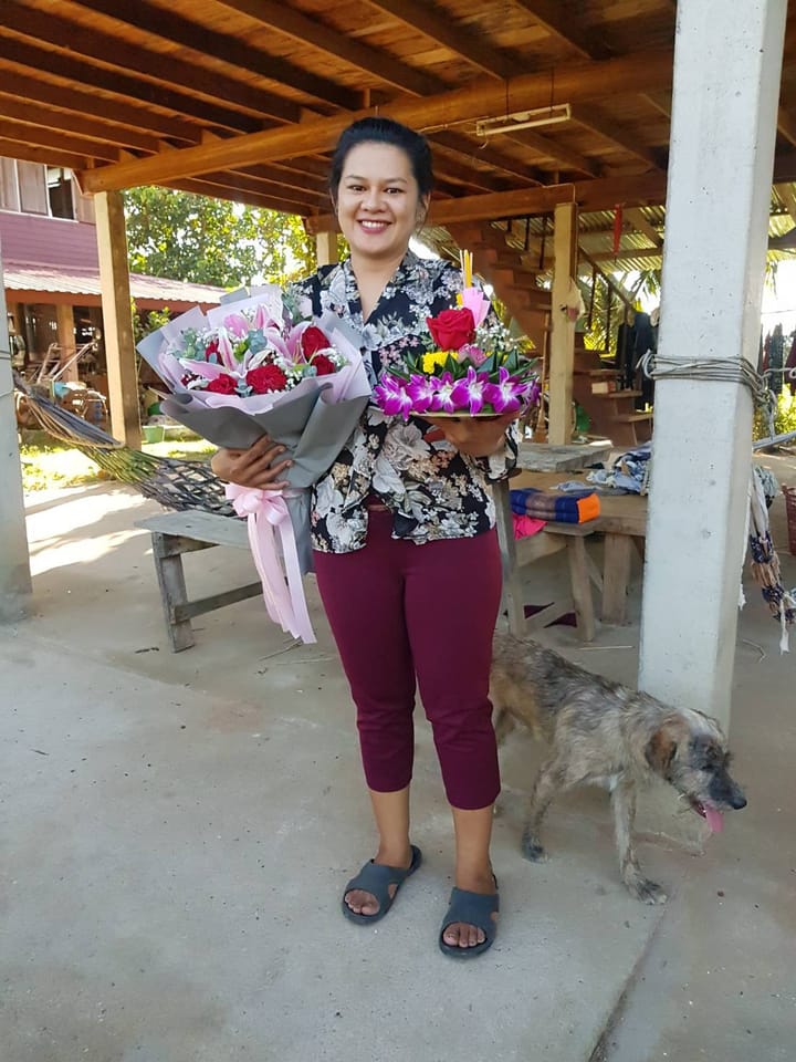 ลูกค้ากำลังรับช่อกุหลาบและกล้วยไม้ สีแดง ชมพู และม่วง (สินค้าอื่น)